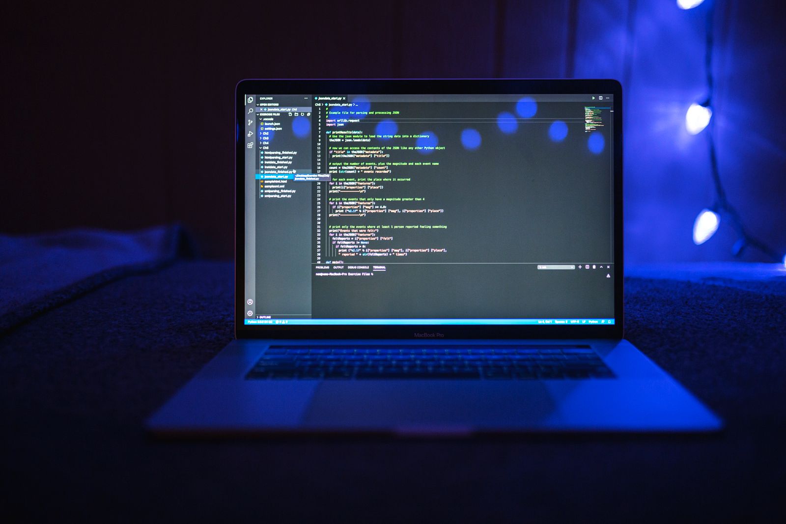 Laptop screen showing a plain-text code file in a dark room