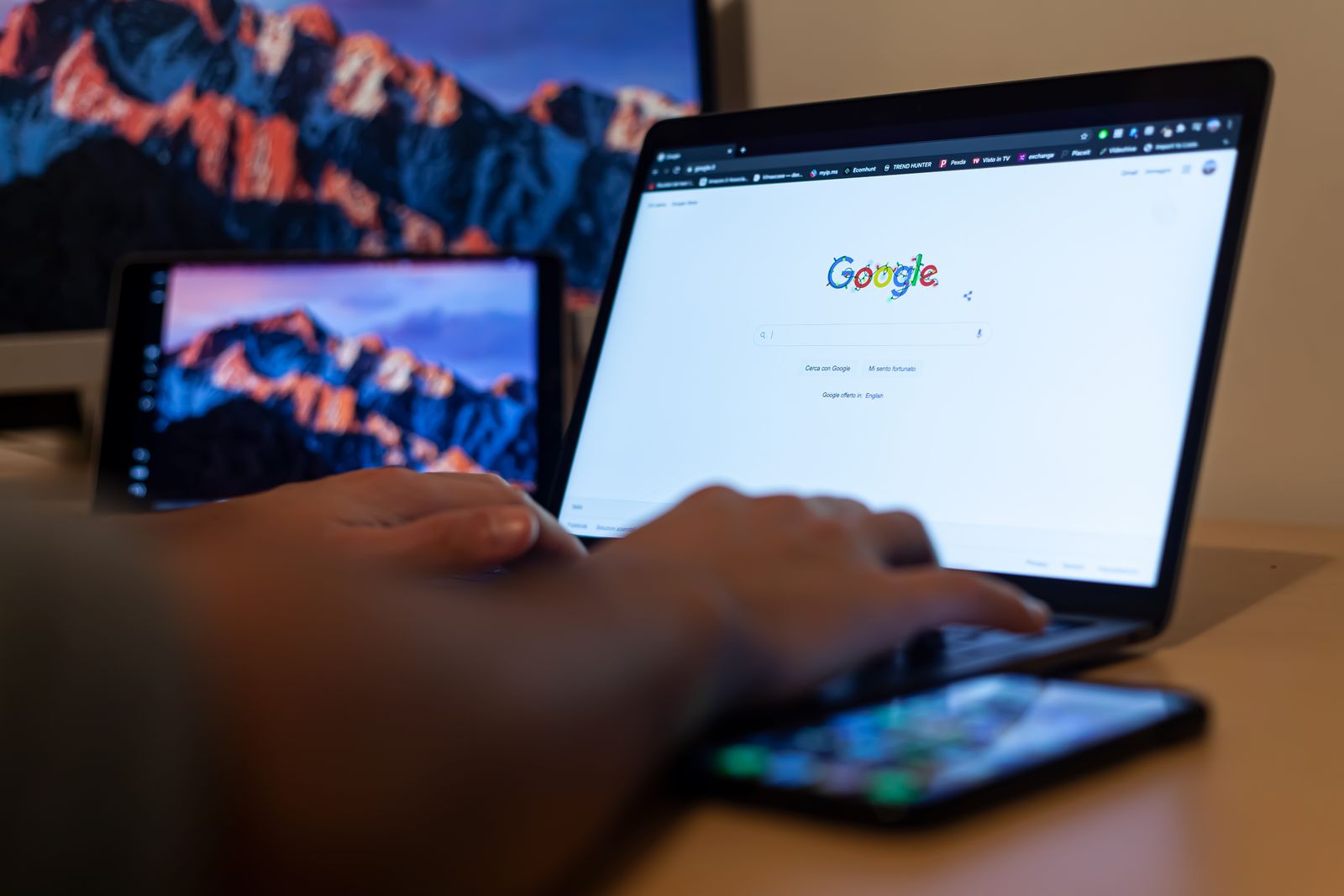 Person typing a query into Google search on a laptop